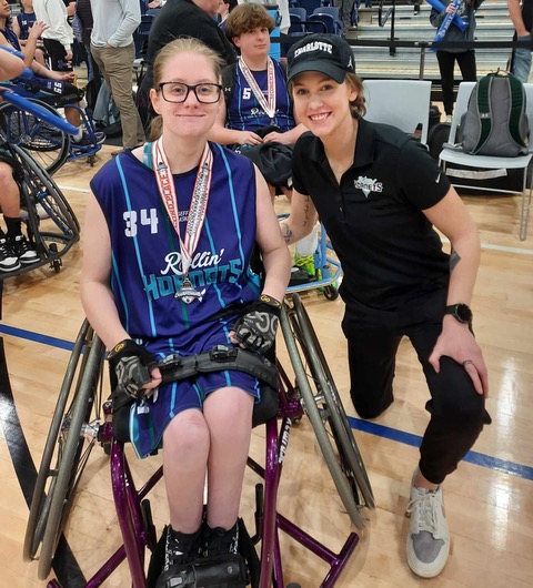 Abby posing with a youth wheelchair basketball player.